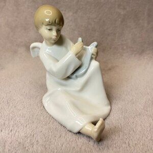 The NAO LLADRO Boy Angel with Lyre Harp Figurine is a small porcelain figurine